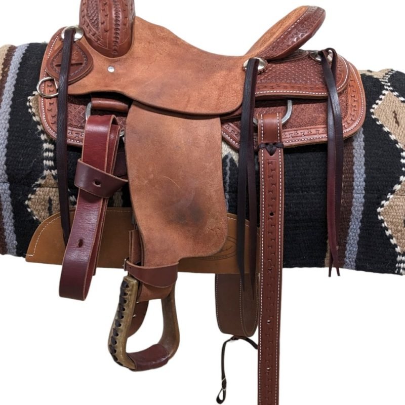 Begin the roping journey early with this new Cashel youth roping saddle, equipped with everything your youngster needs to start roping! Featuring a rough-out hard seat, jockeys, and fenders for a secure grip, the leather showcases attractive basket stamp tooling. Complete with a rear cinch, this saddle is tailored for young riders ready to embark on their roping adventures.
